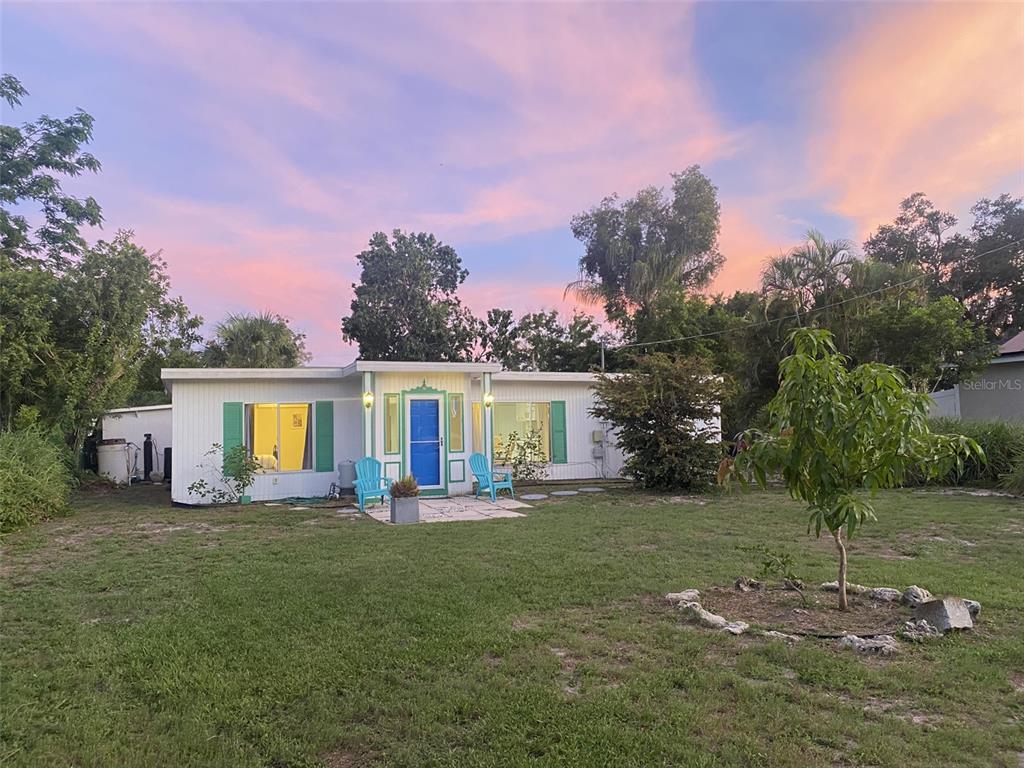 a front view of house with yard and trees in the background