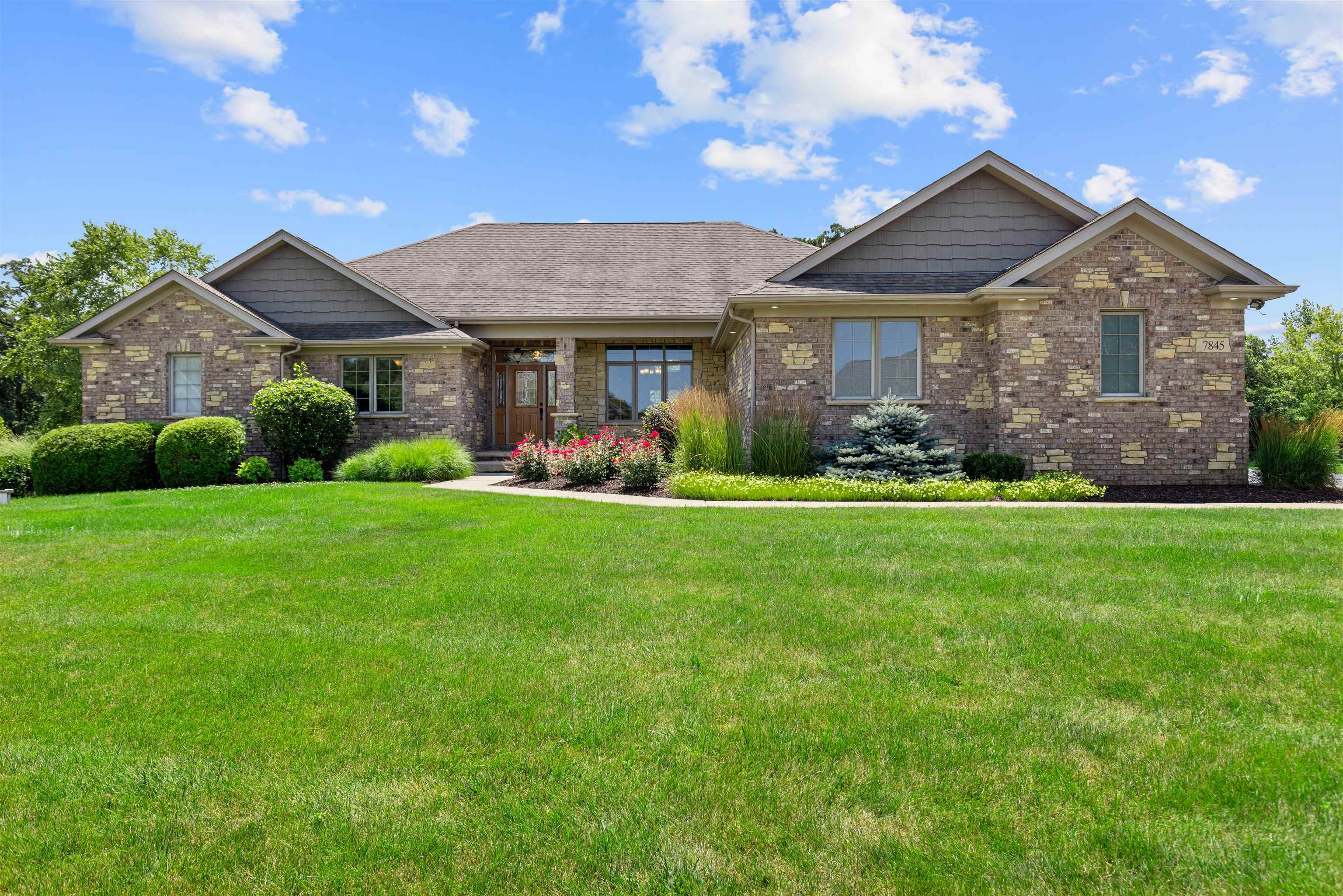 a front view of a house with a garden and plants