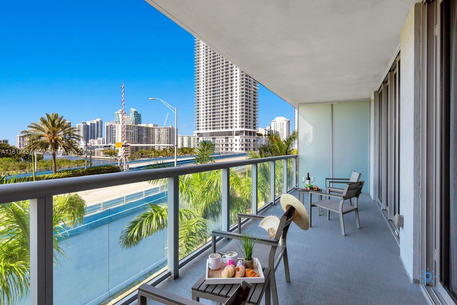 a view of a city from a balcony with furniture