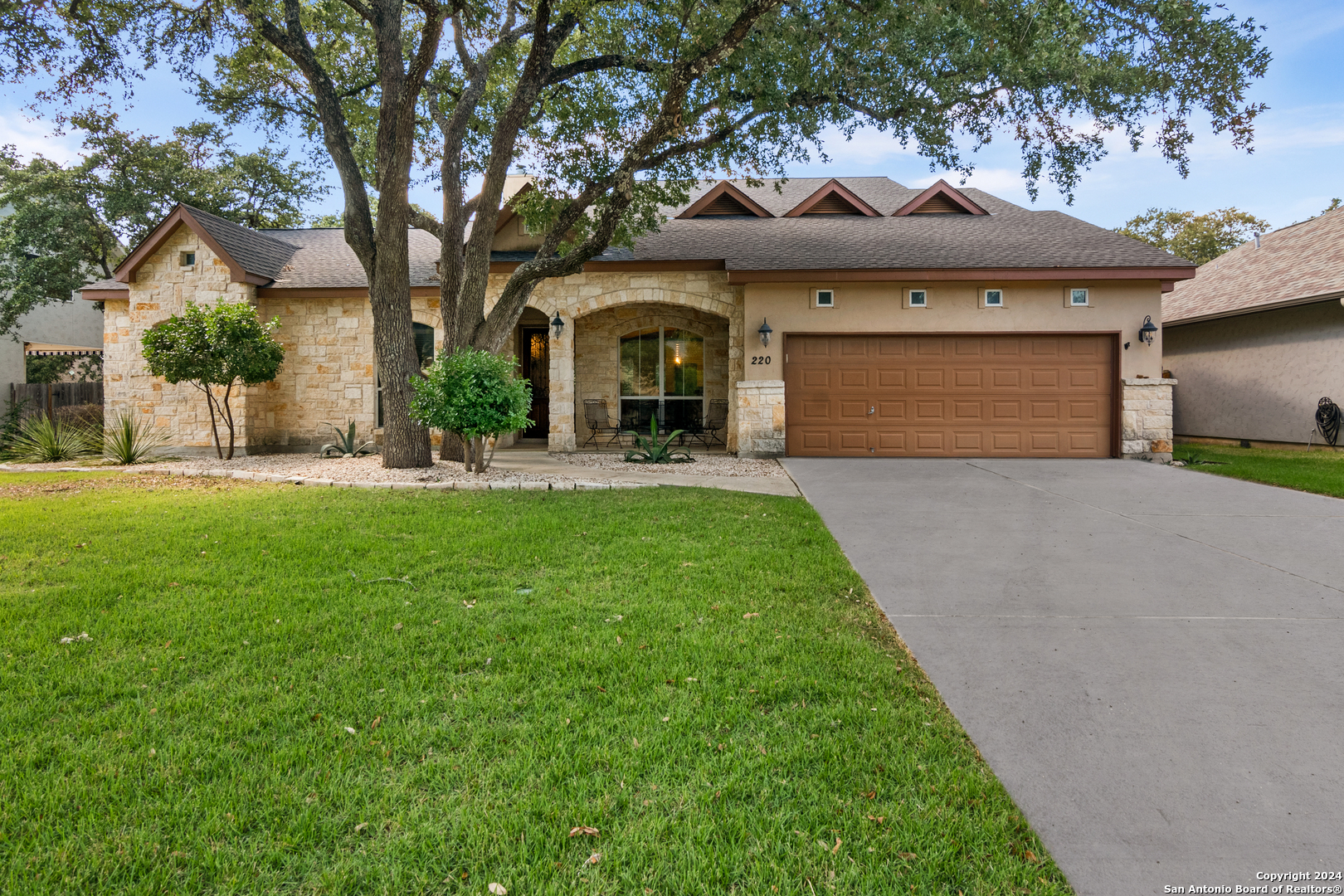 a front view of a house with a garden and yard