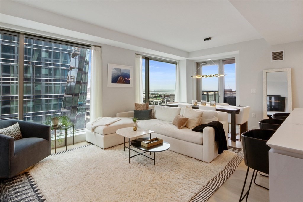 a living room with furniture wooden floor and a large window