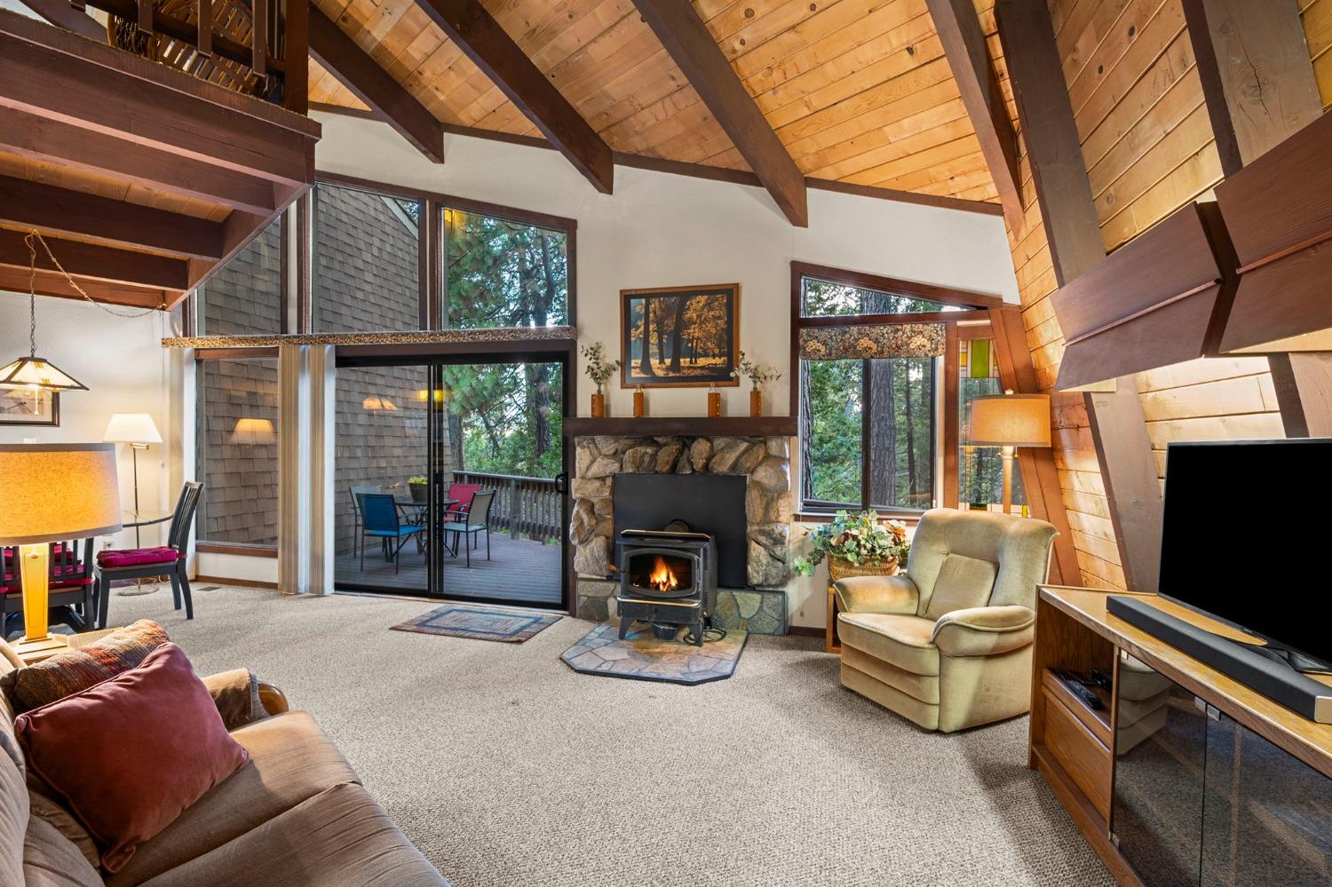 a living room with furniture a fireplace and a flat tv screen next to a window