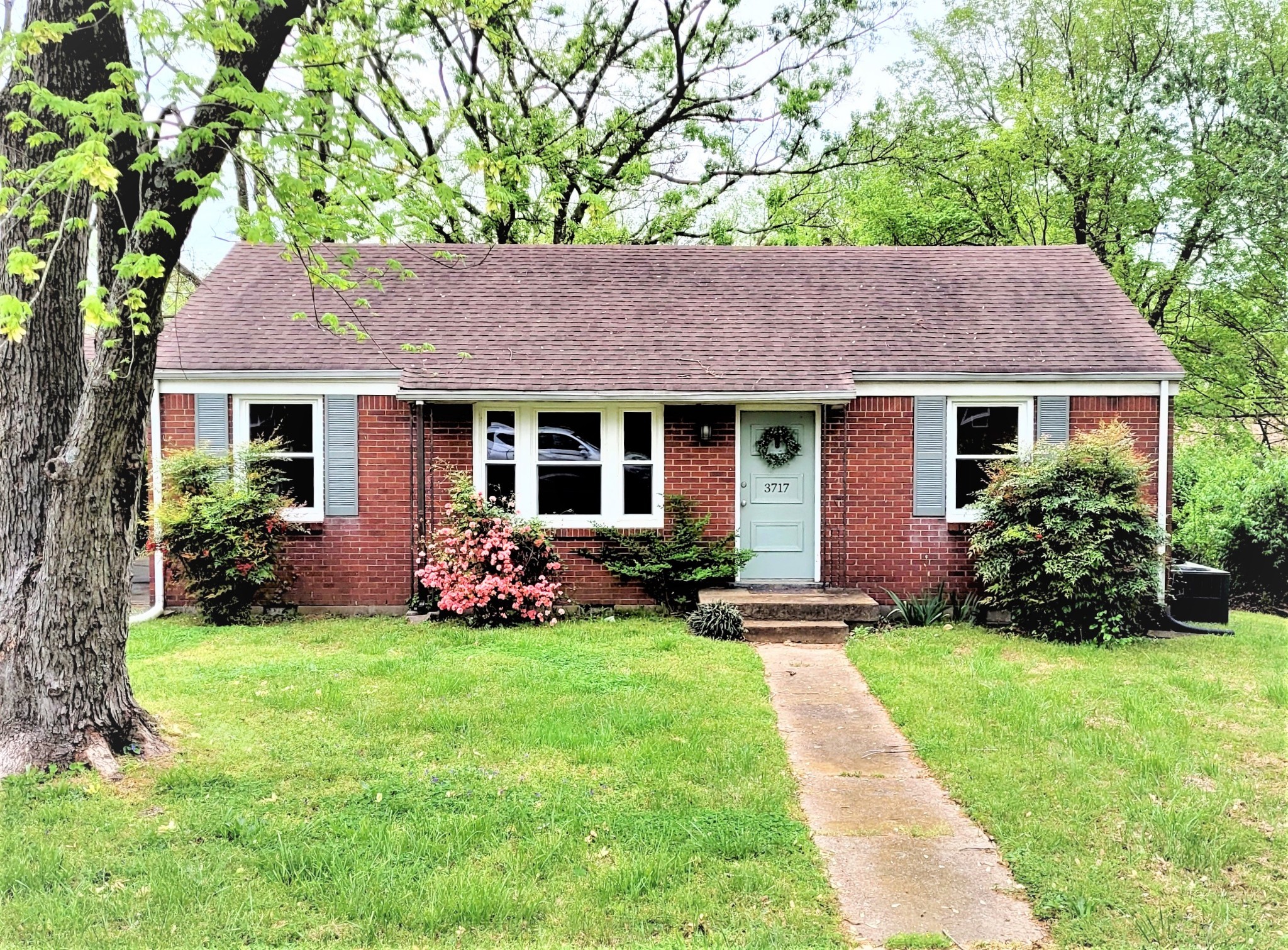 a front view of a house with a garden