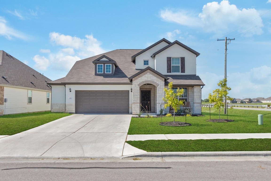 a front view of a house with a yard and garage