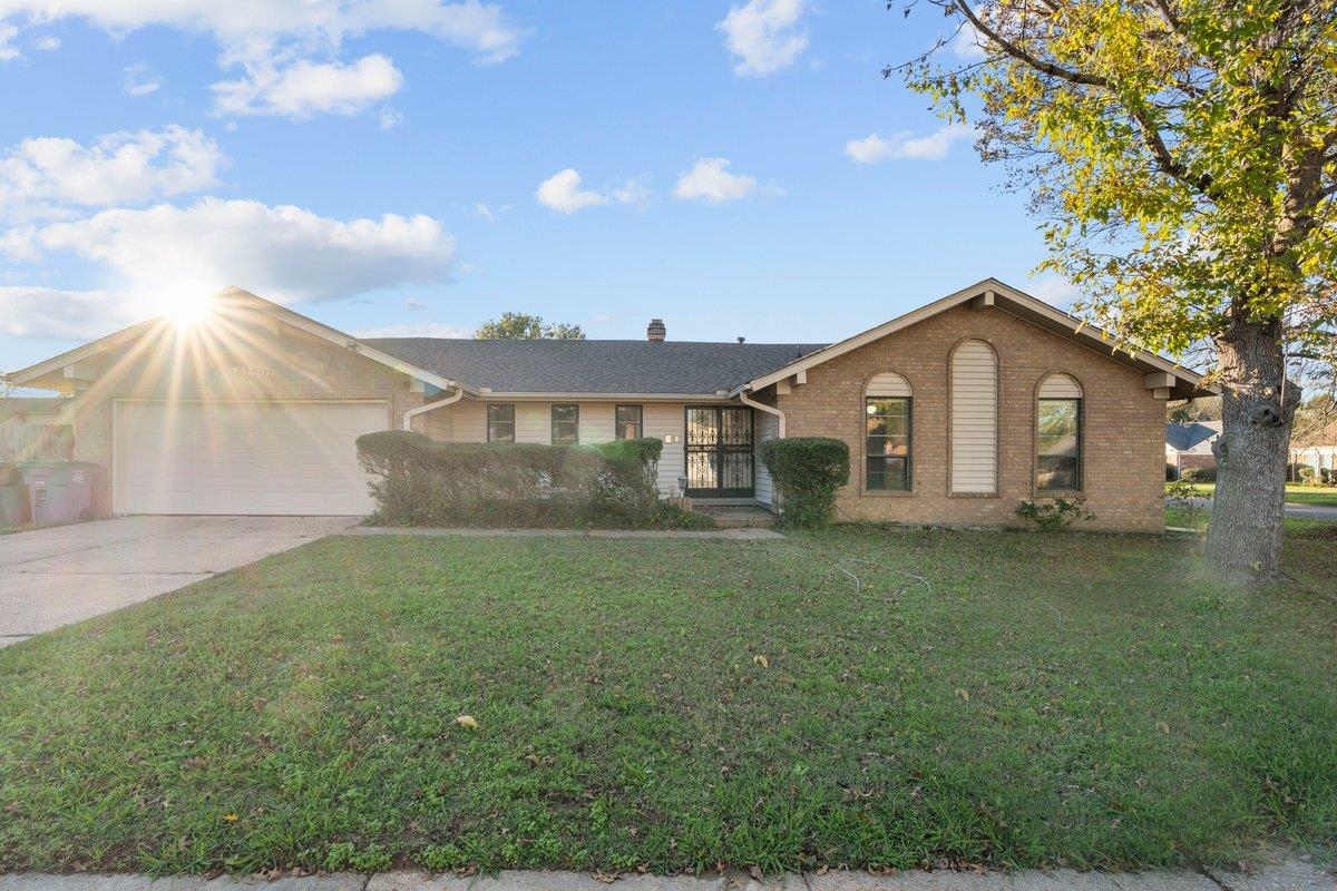 Ranch-style house featuring a front lawn and a garage