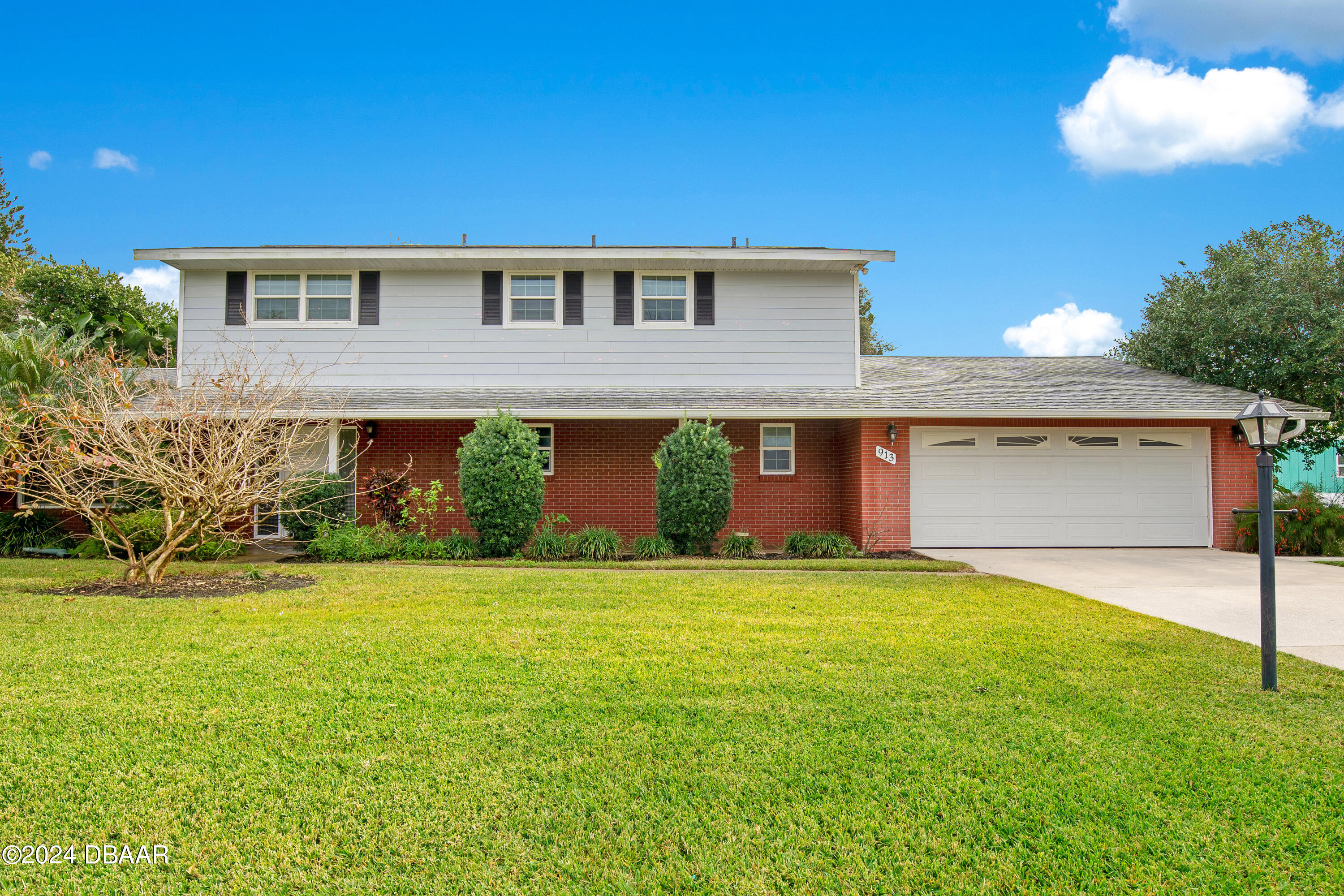 a front view of house with yard and trees in the background