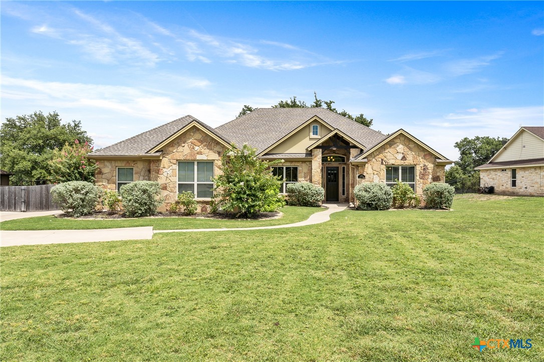 a view of a house with a big yard and large trees