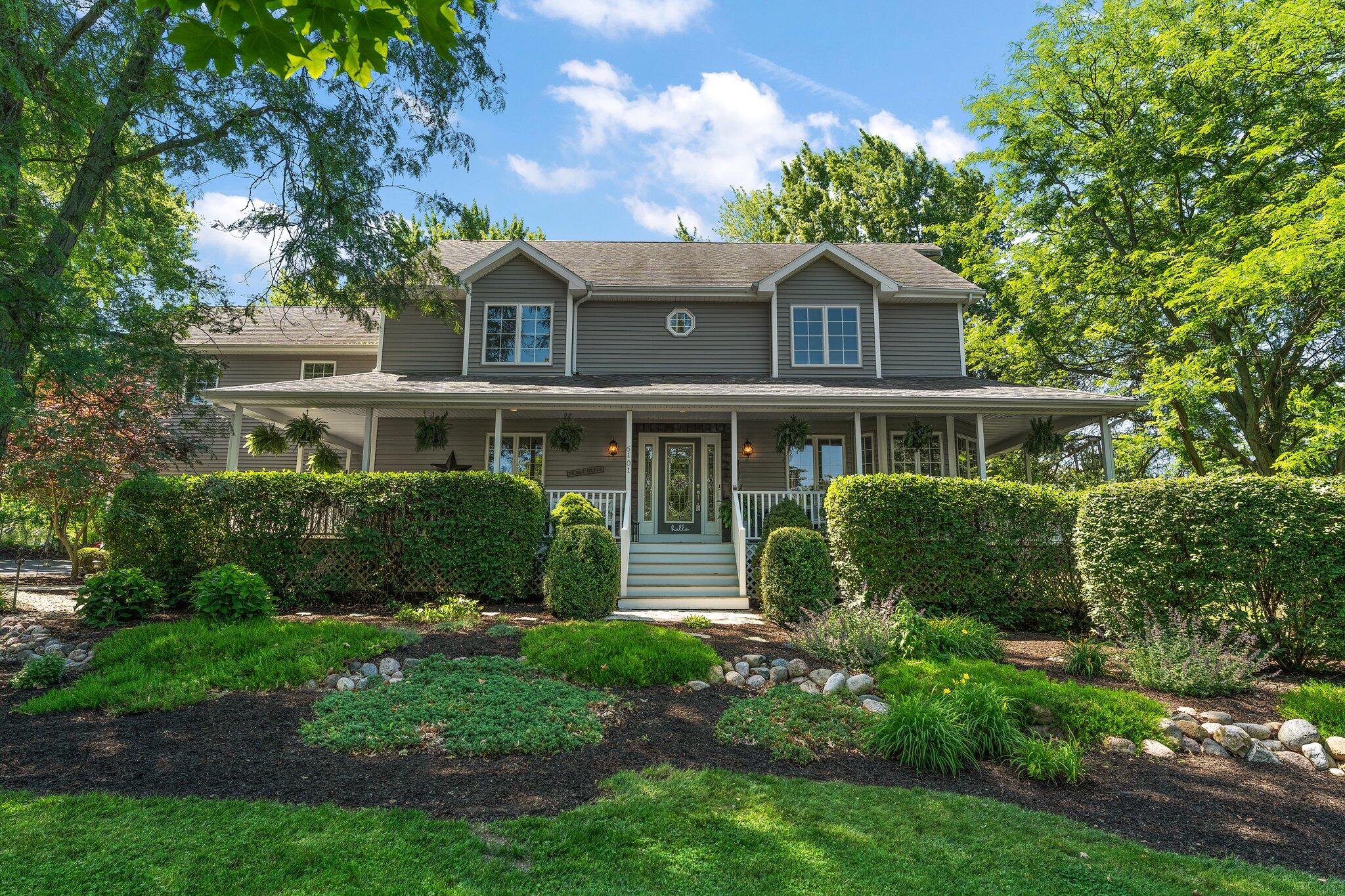 a front view of a house with a yard and potted plants