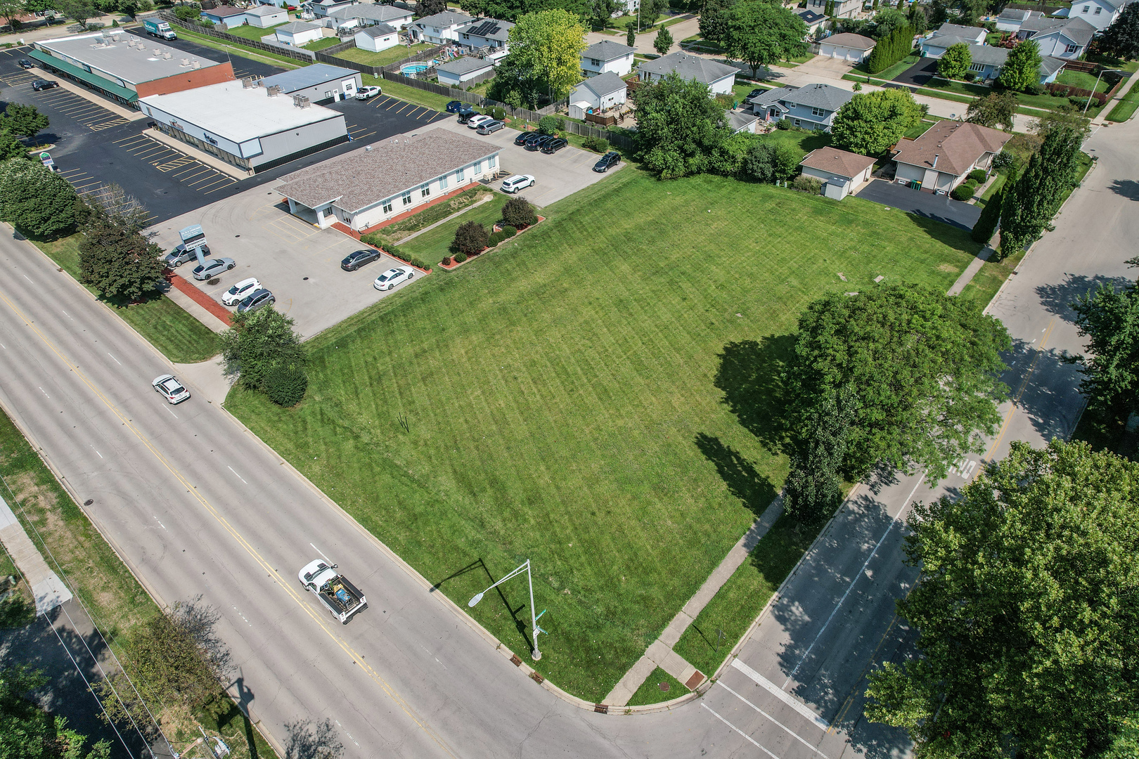 an aerial view of a residential houses with outdoor space and street view