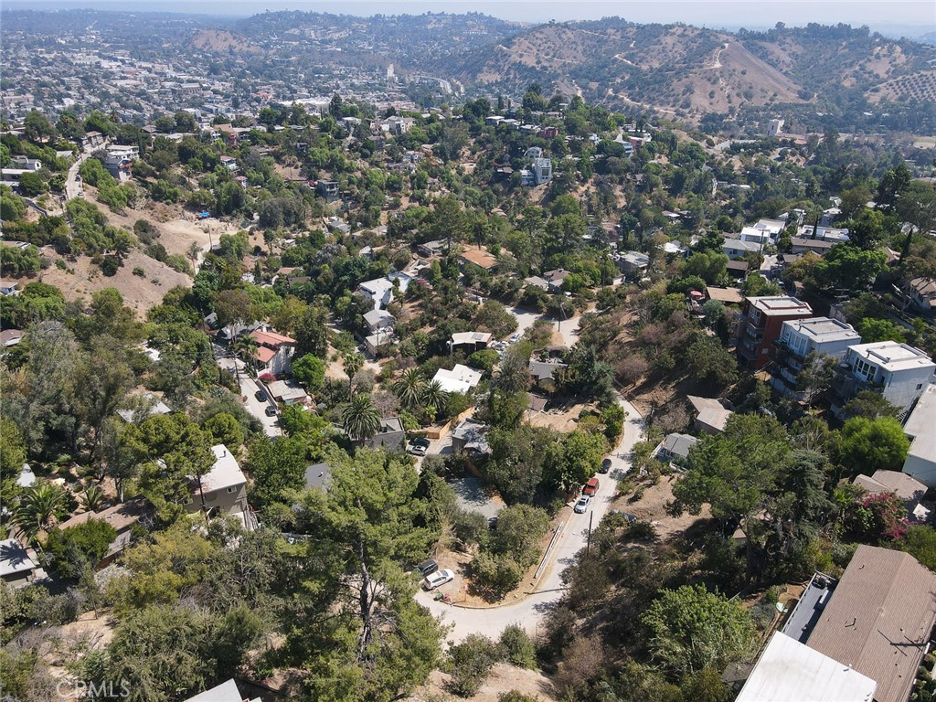 an aerial view of a houses with a lush green hillside