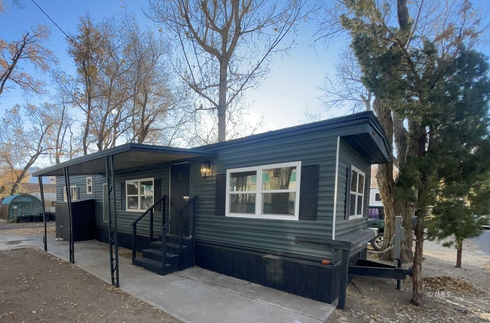 a front view of a house with a tree