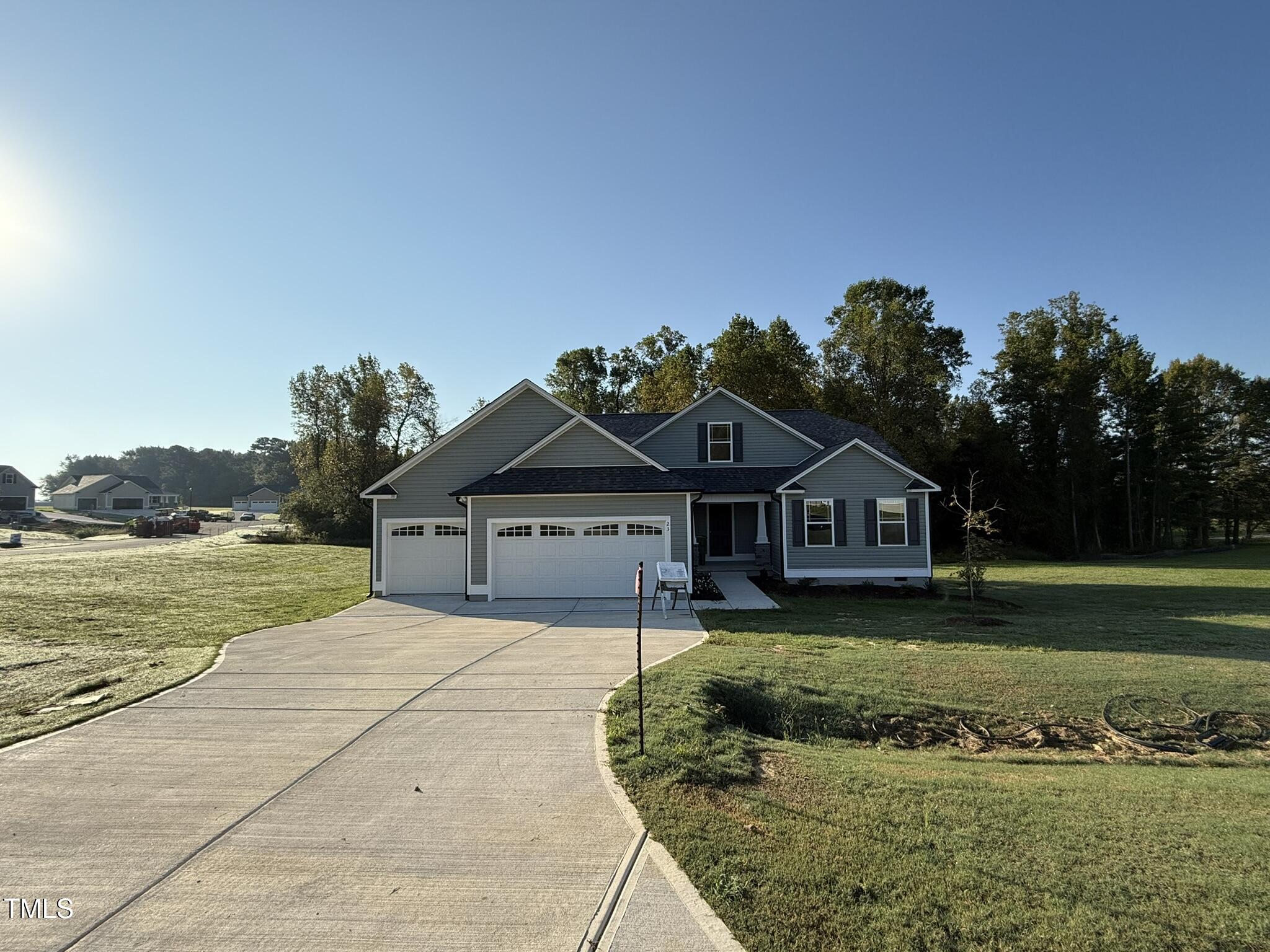 a front view of a house with a garden and yard