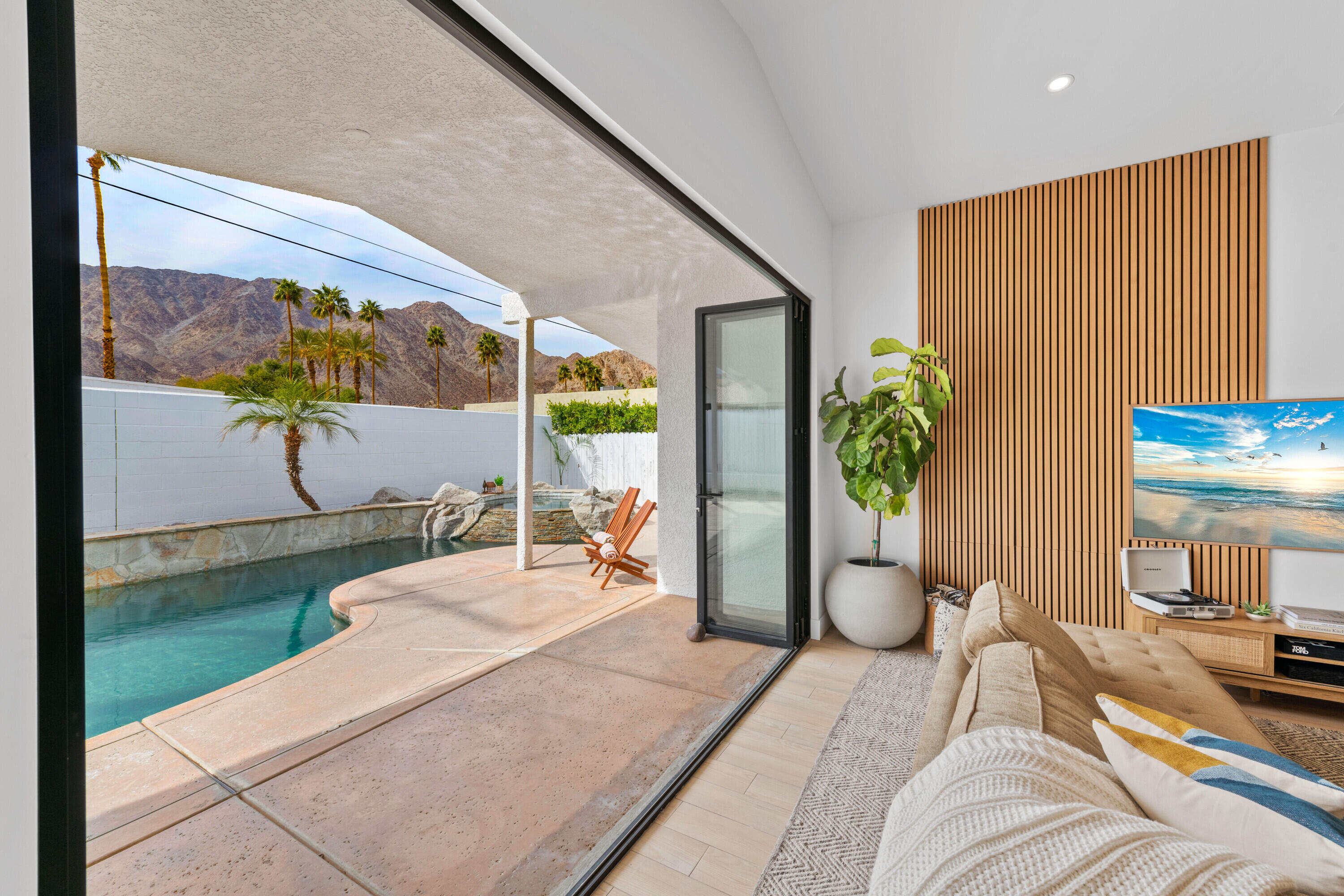 a bedroom with a bed a potted plant and a large window