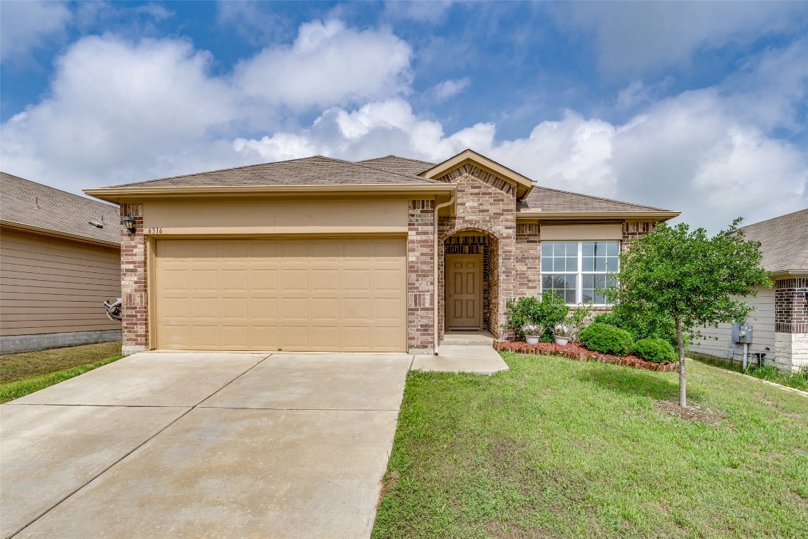 a front view of a house with a yard and garage