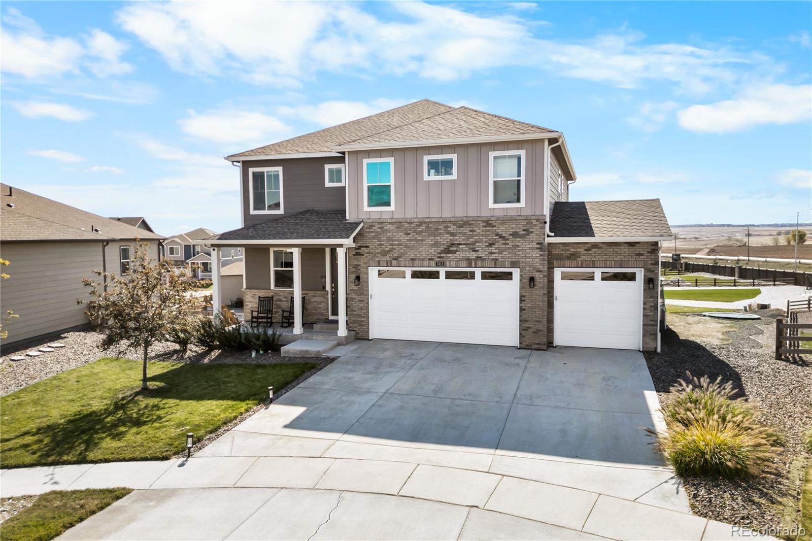 a front view of a house with a garden and parking