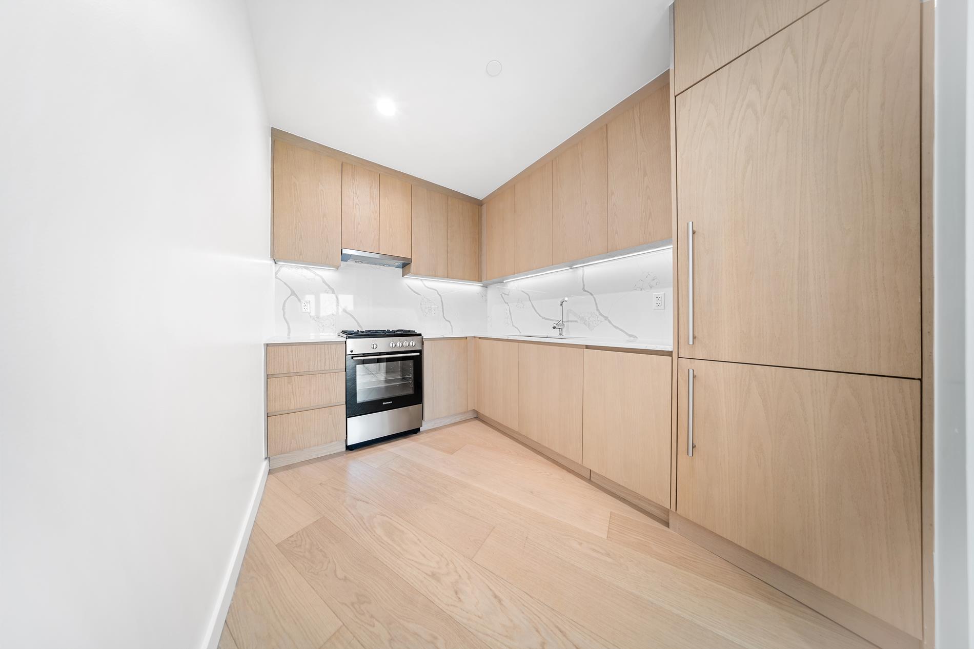 a kitchen with granite countertop white cabinets and stainless steel appliances