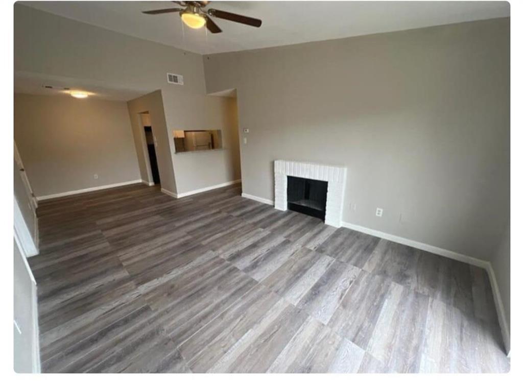 a view of an empty room and window with wooden floor