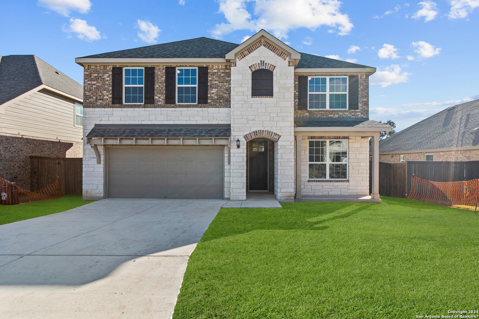 a front view of a house with a yard and garage