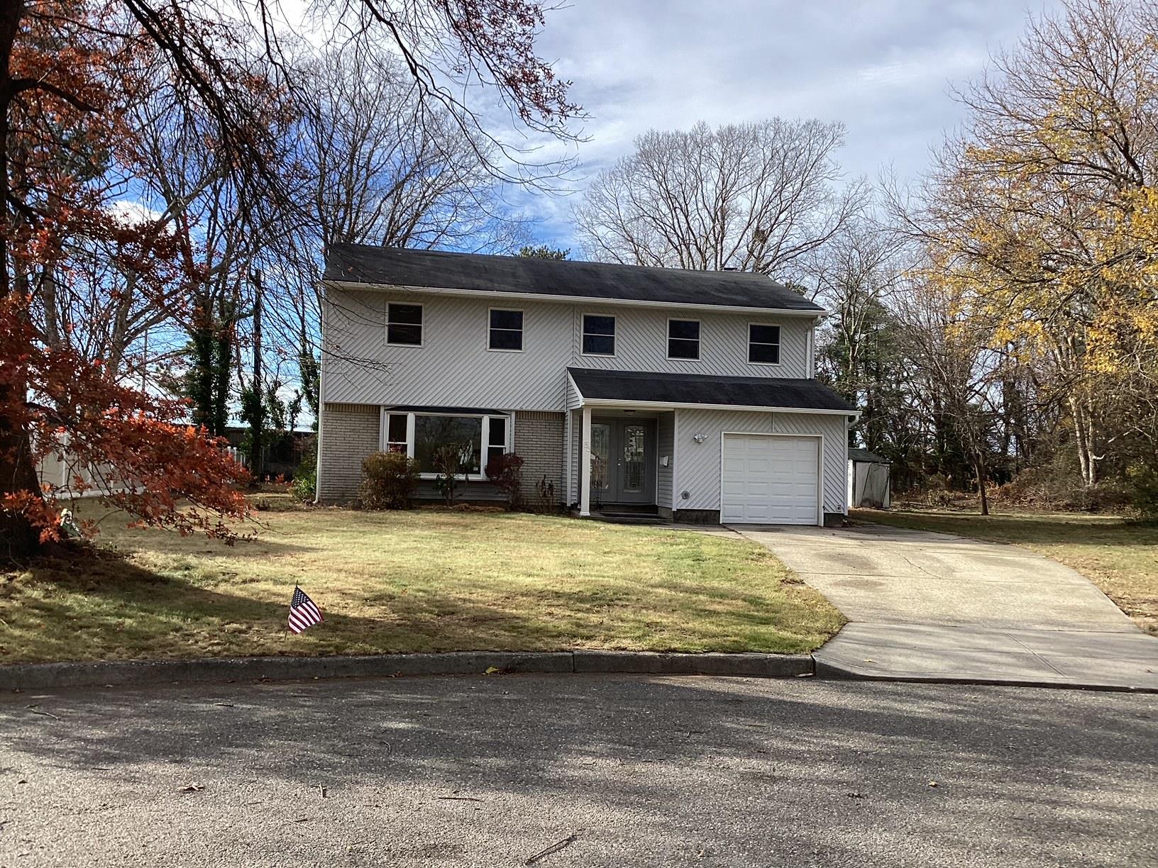 View of front property featuring a garage and a front lawn