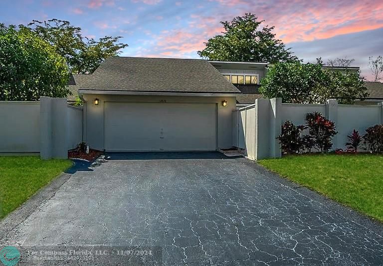 a view of a house with a yard and a garage