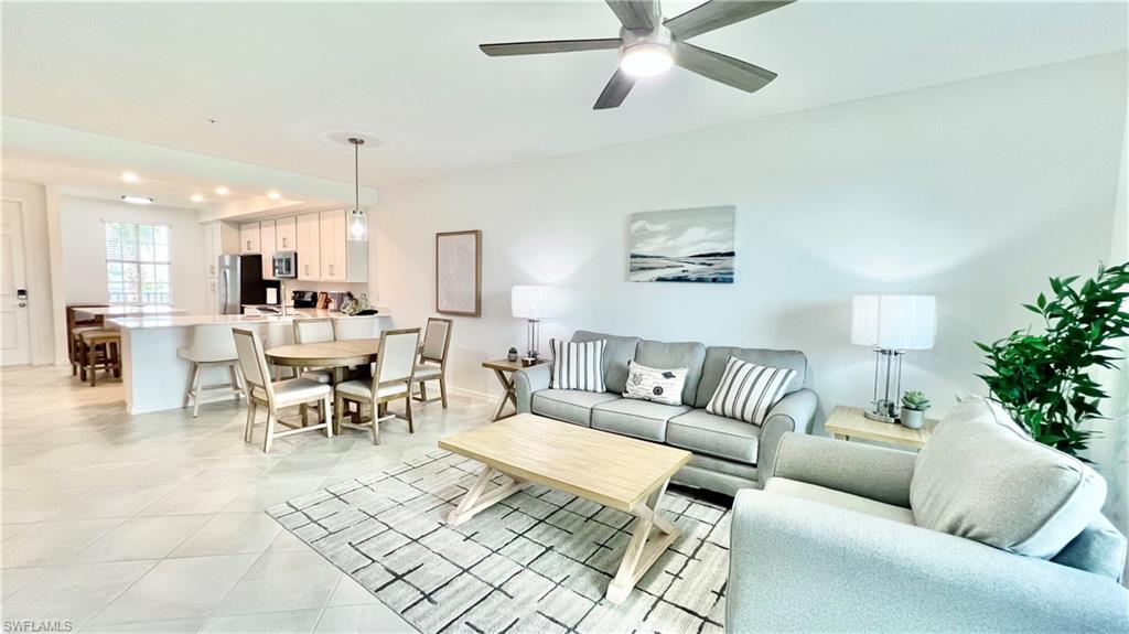 a living room with furniture and a view of kitchen