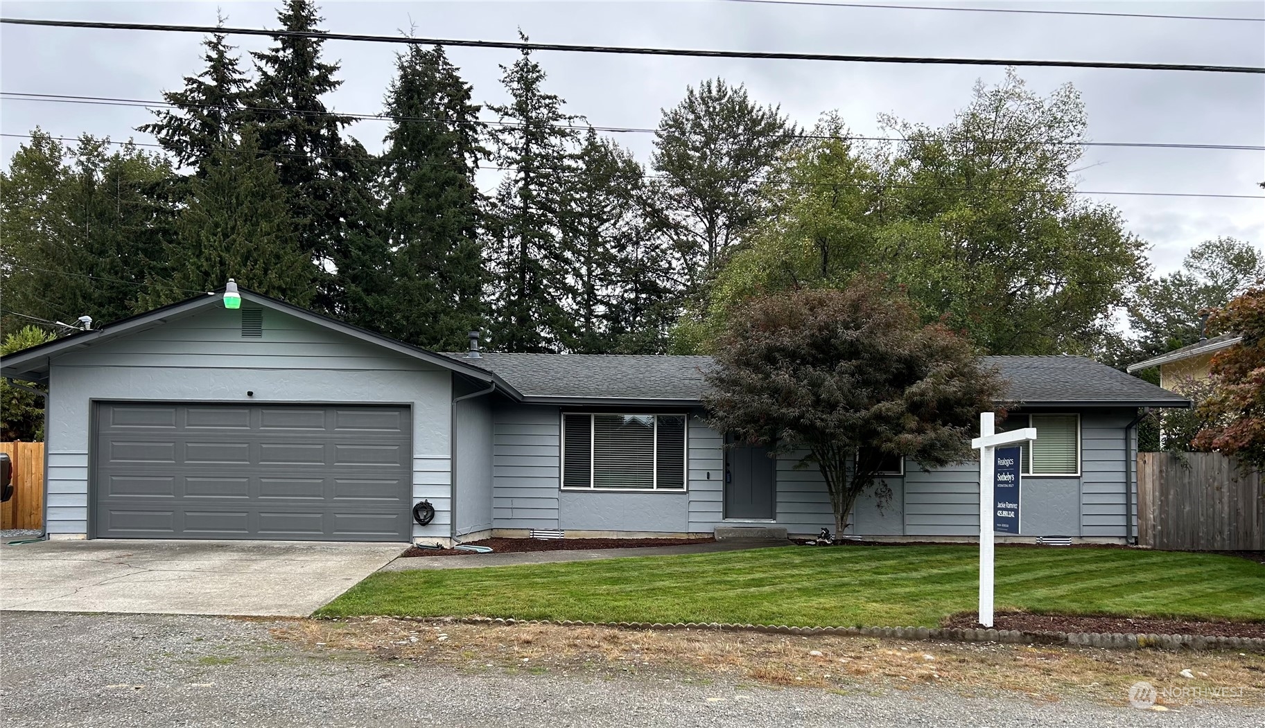 a front view of a house with a garden and trees