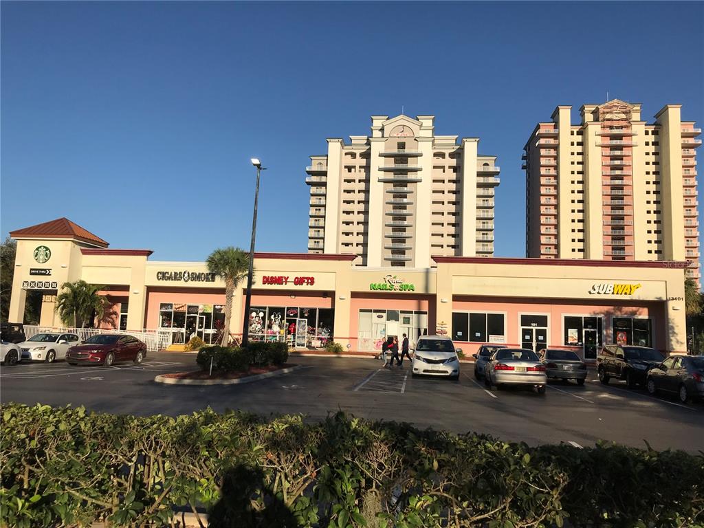 a front view of a building with lot of cars parked