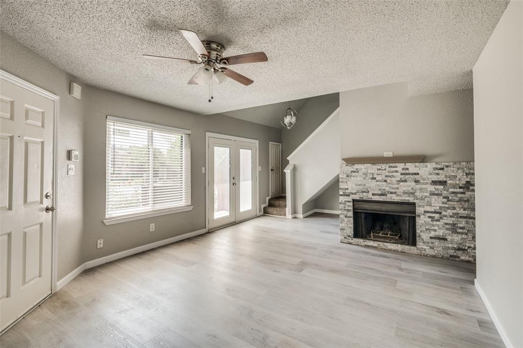 a view of an empty room with window and fire place