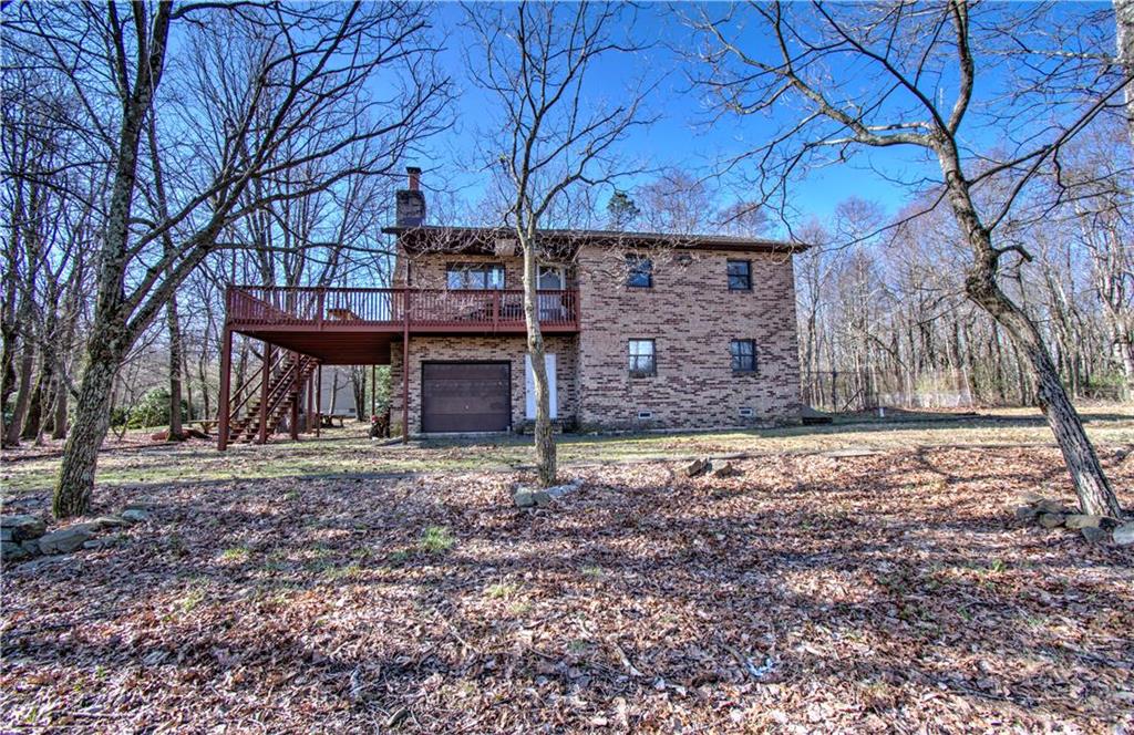 a view of a house with a yard tree and wooden fence