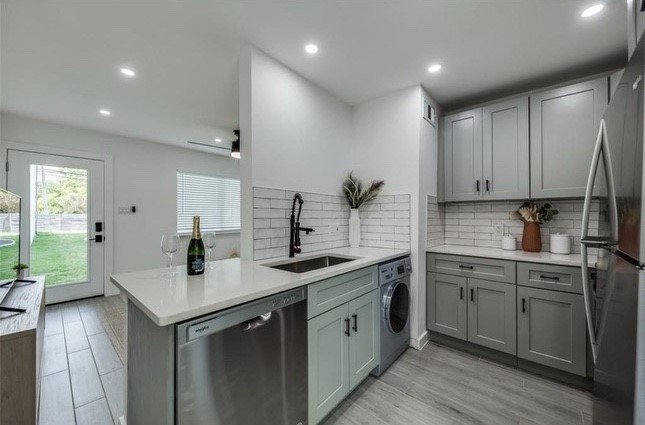 a kitchen with sink refrigerator and cabinets