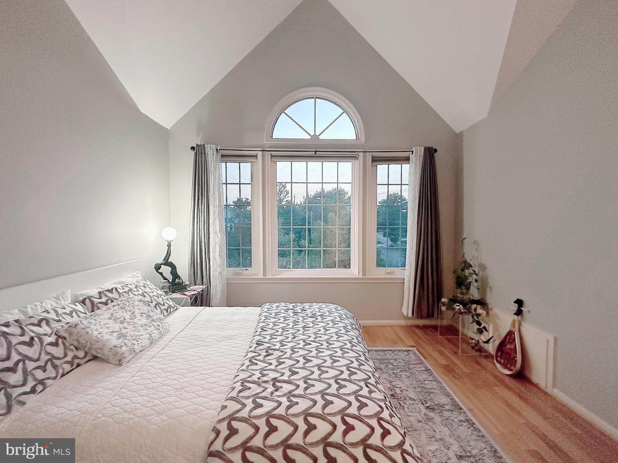 a bedroom with a bed and a large window