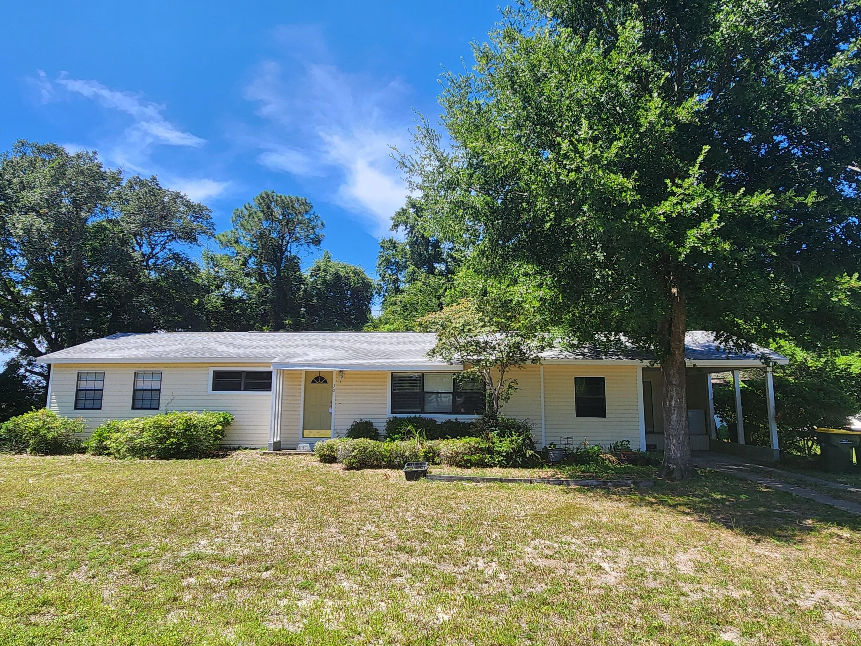 a view of a house with backyard and tree