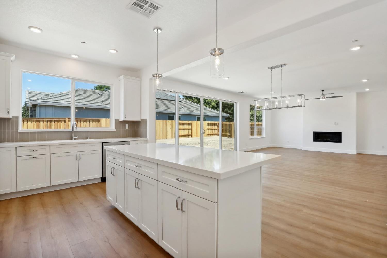 a kitchen with a sink window and wooden floor