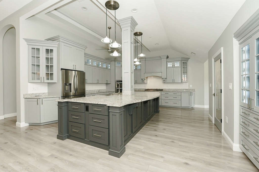 a large kitchen with kitchen island a sink stainless steel appliances and cabinets