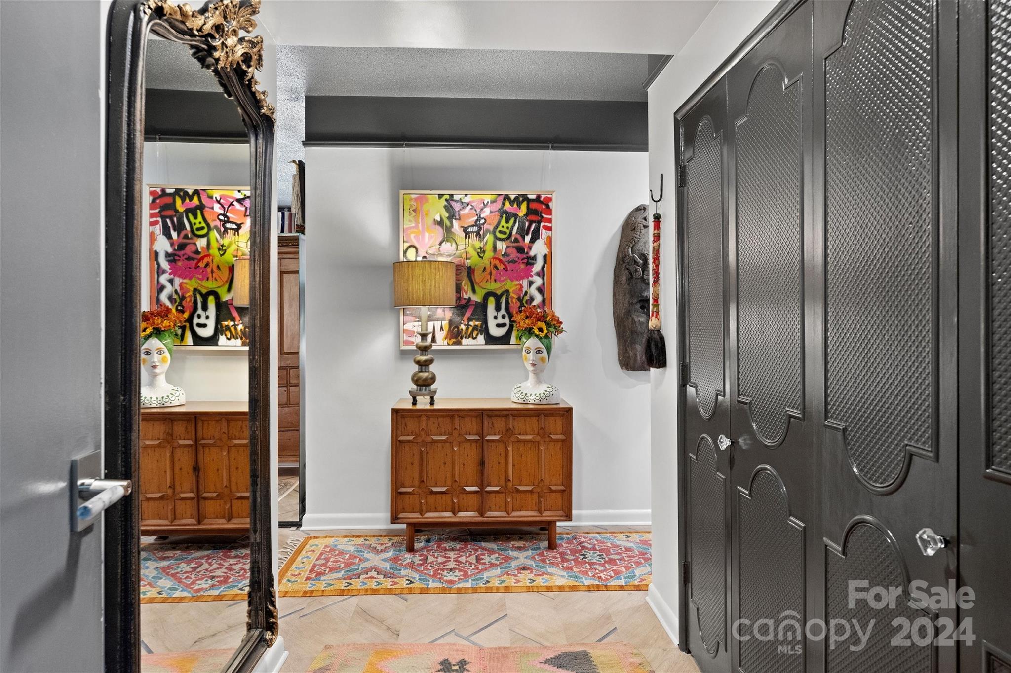 a view of a hallway with front door and wooden floor