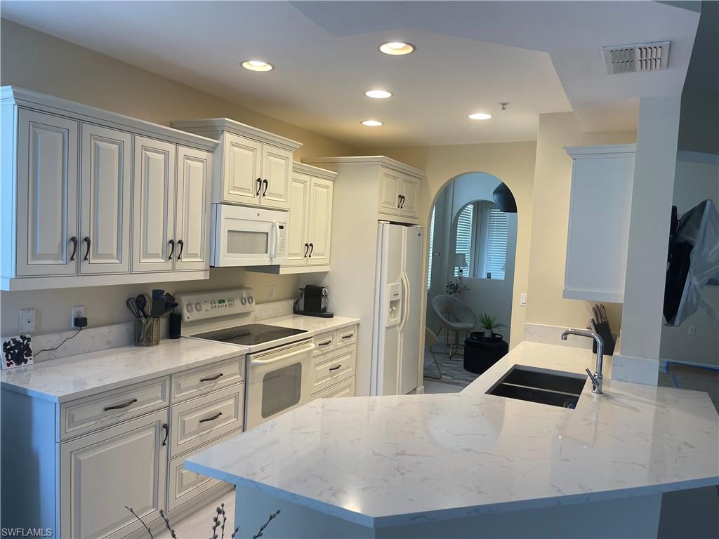 a kitchen with white cabinets and stainless steel appliances