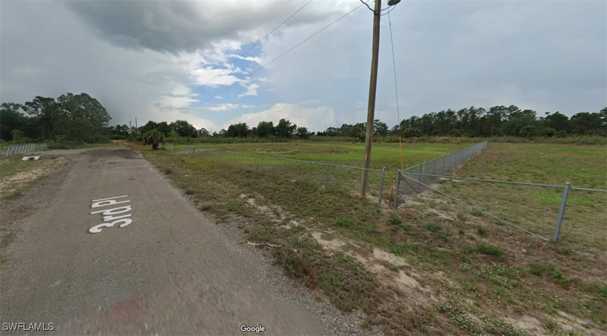 a view of a street with a big yard