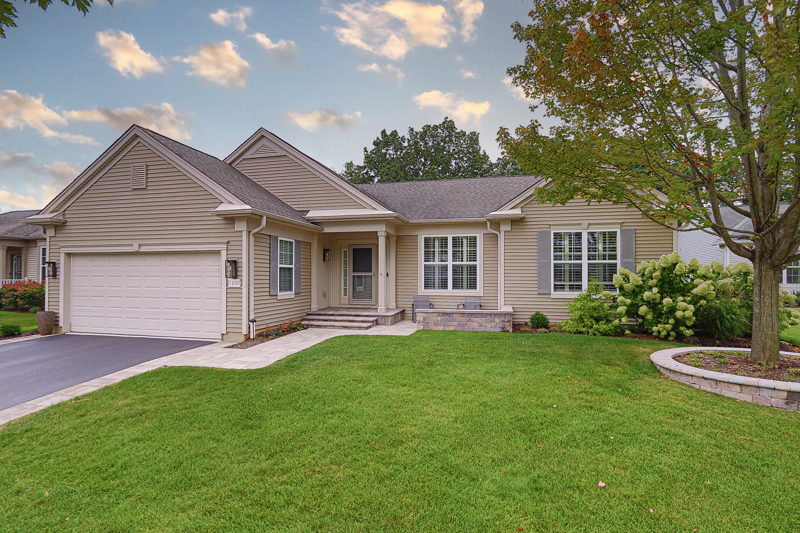 a front view of a house with a garden and yard