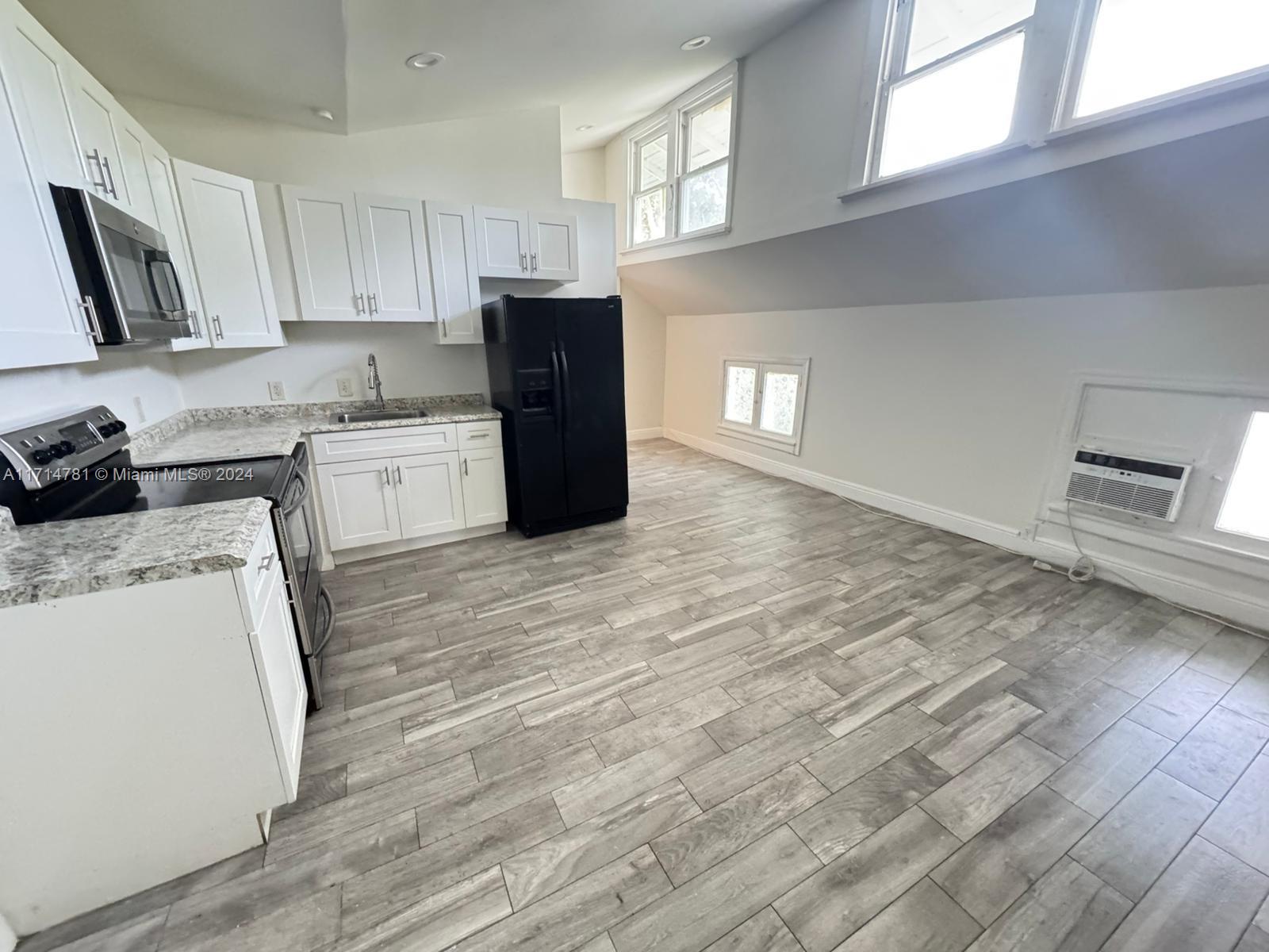 a kitchen with granite countertop a refrigerator stove top oven and sink