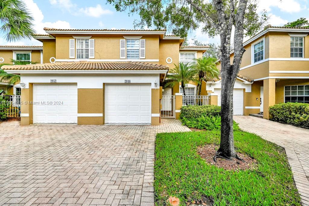 a front view of a house with a yard and garage