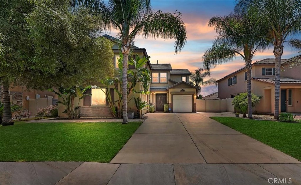 a view of a white house with a yard and palm trees