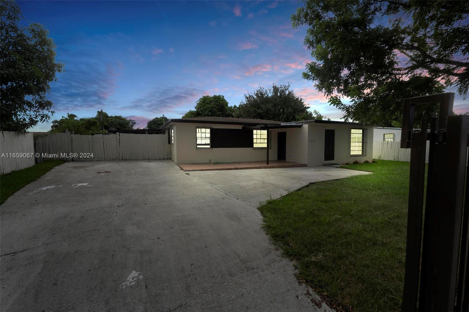 a front view of a house with a yard and trees