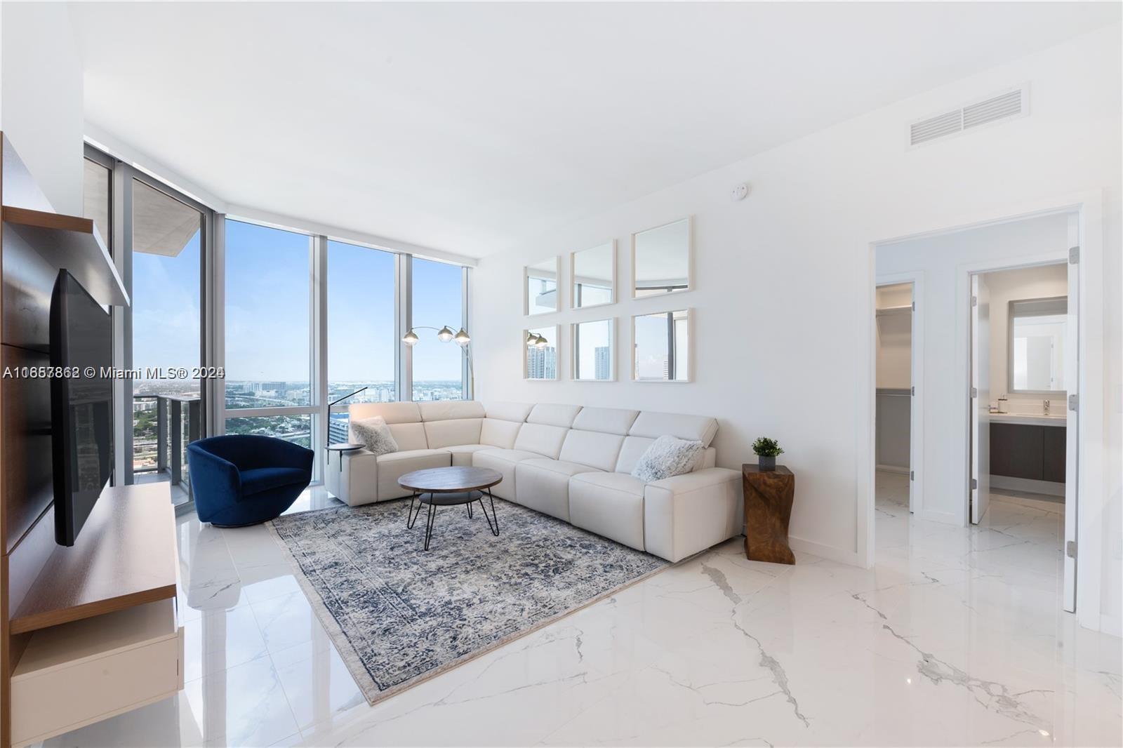 a living room with furniture and a view of kitchen