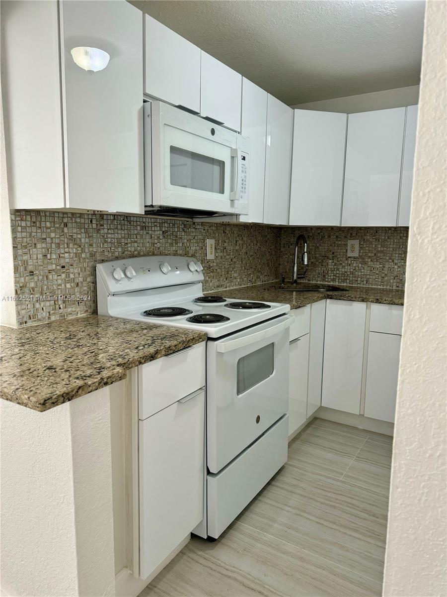 a kitchen with stainless steel appliances granite countertop a sink and a stove