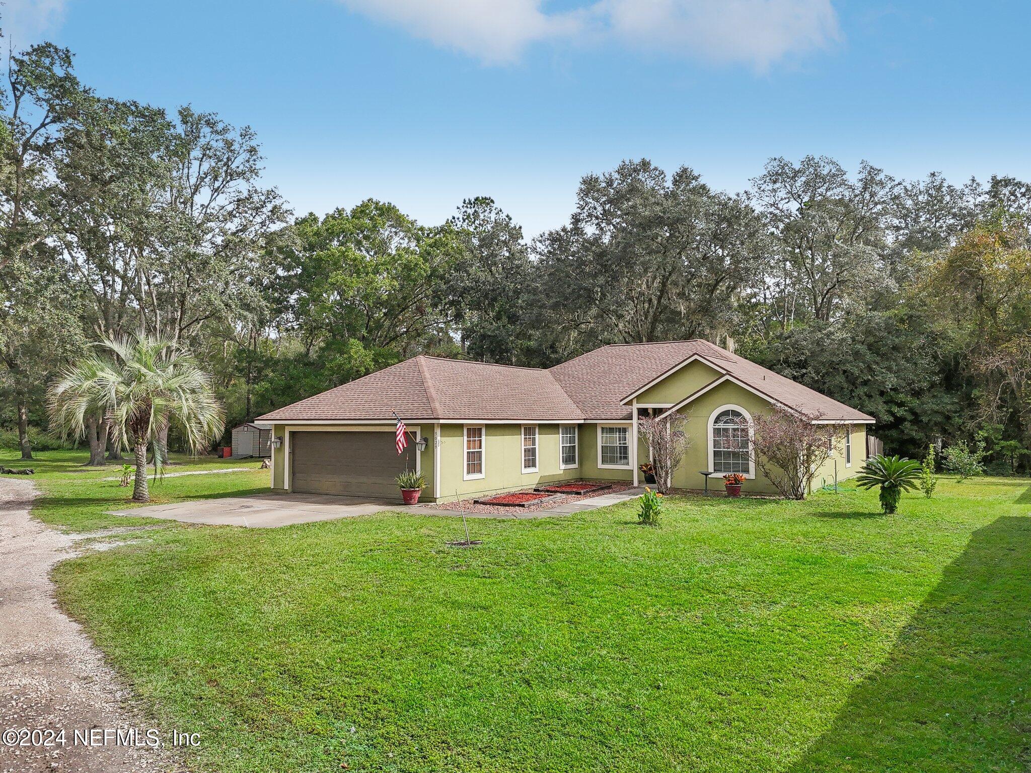 a front view of a house with a yard and green space