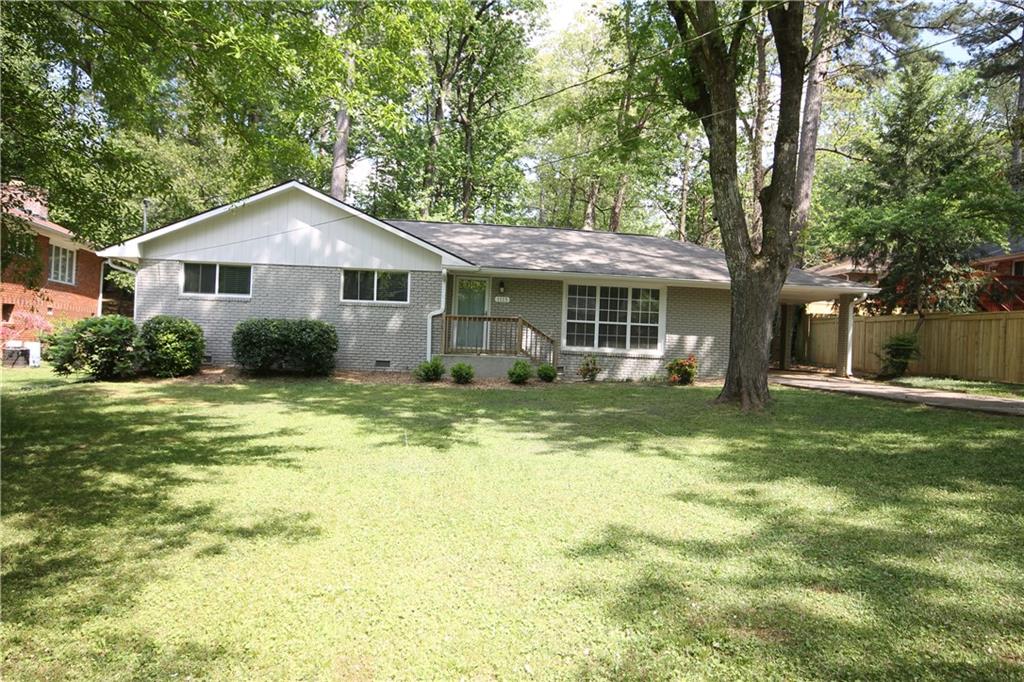 a front view of a house with a yard and trees