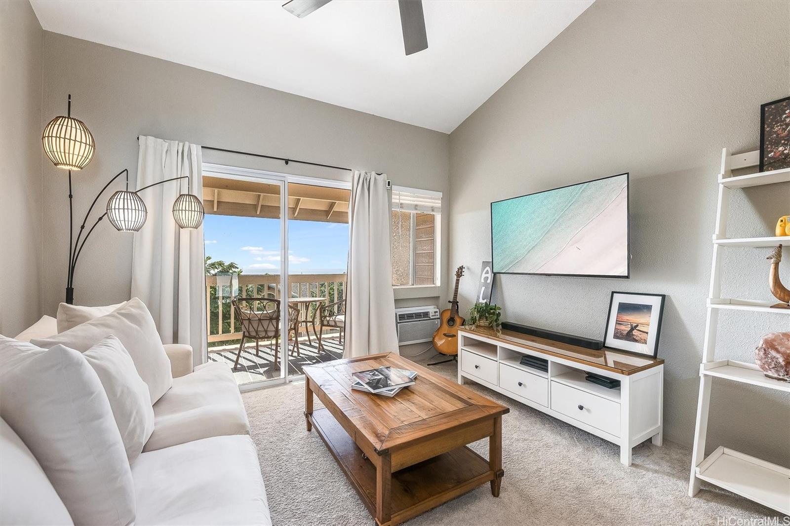 a living room with furniture a flat screen tv and a window