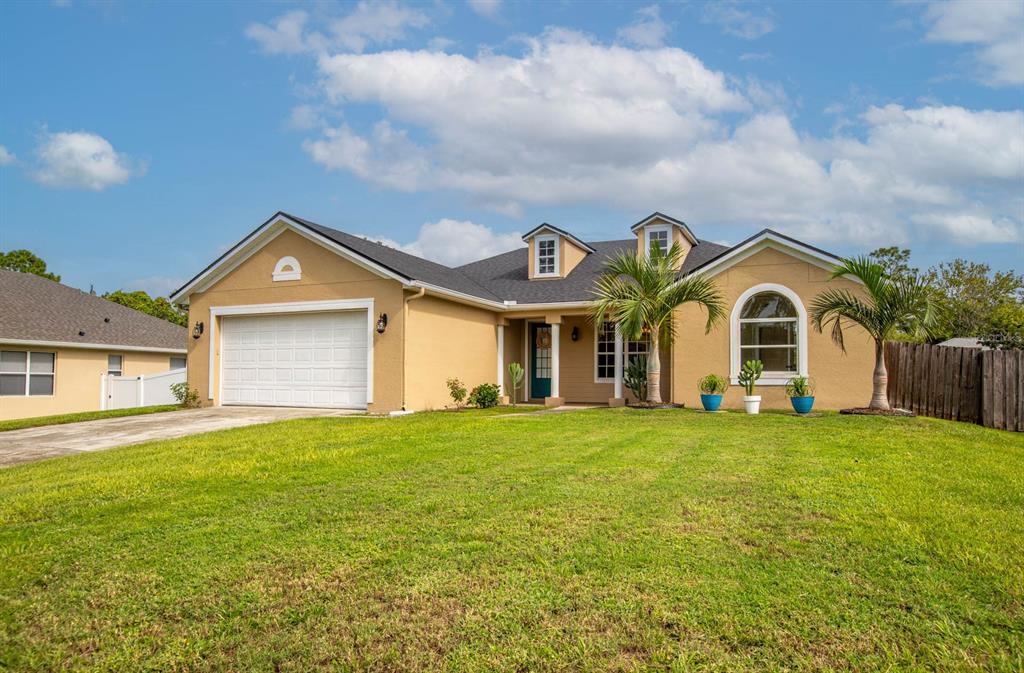 a front view of a house with yard and green space