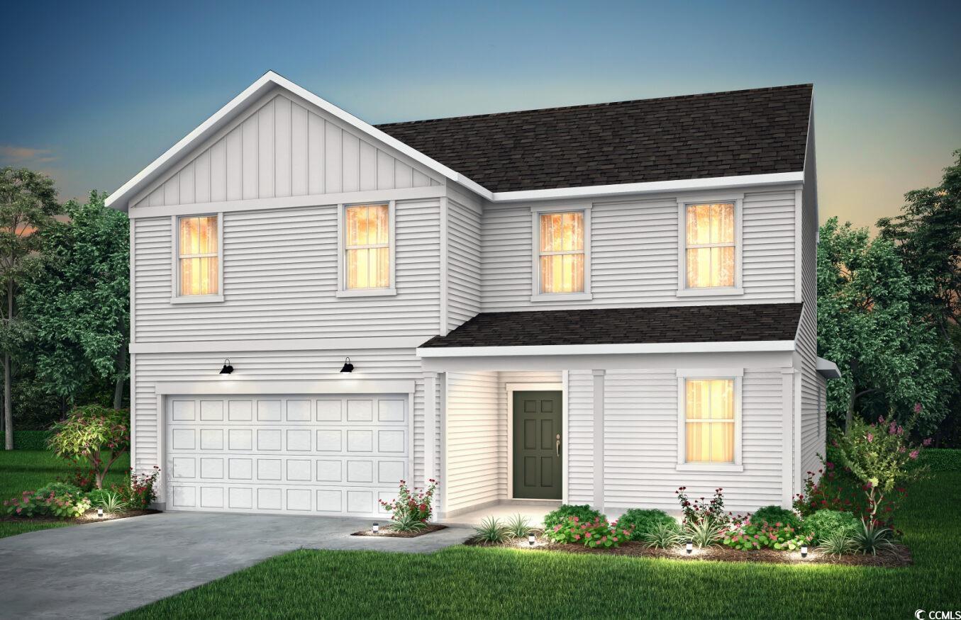 View of front facade with a yard and a garage