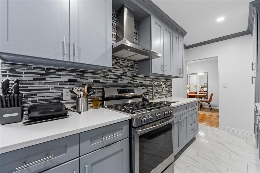 a kitchen with stainless steel appliances granite countertop a stove a sink and a white cabinets